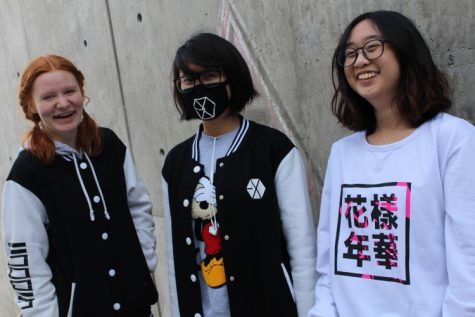 Pheobe Tran, Heidi Gertzki, and Varintorn Nivasnandas pose with some kpop shirts 