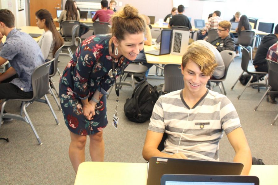 English+teacher+Corrie+Myers+helps+a+student+revise+his+college+application.+