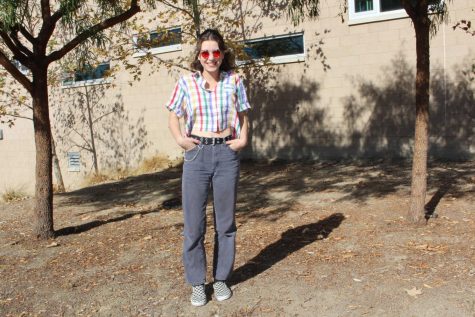 Junior Skylar Johnson rocks a retro colorful button down that she ties with baggy faded blue jeans. She adds accessories like a big black belt, checkered Vans, red old school glasses and a silver chain. She gets the majority of her clothes from other vendors when they swap back and forth on Depop. Check out her shop on Depop! https://www.depop.com/scaryskylar