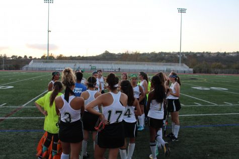 Girls field hockey team huddles up before a game.