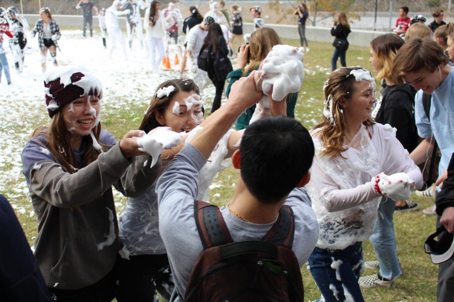 Seniors Shay Greaney and Makenna Manti are pictured throwing the snow in hopes of dousing their friend, Tyler Sun, in the white soap.