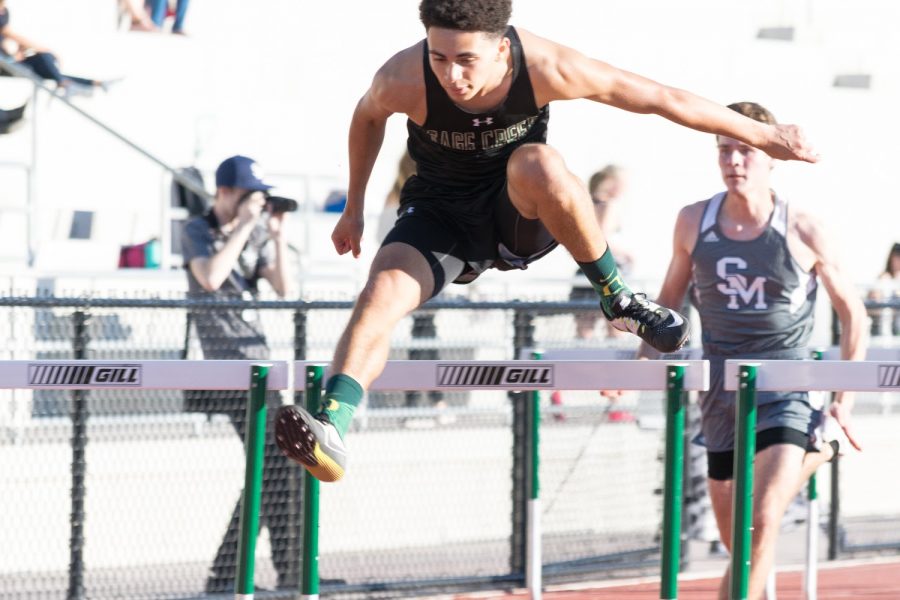 Jordan Lee bounding over the 3.5 foot high hurdle, another athlete from San
Marcos follows close behind. Although Jordan was only a sophomore when this picture
was taken, he still dominated every race.