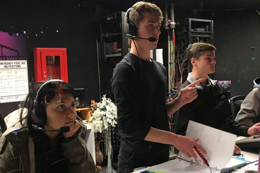 Stage Manager Nathan Waits reviews the multitude of light cues for Footloose with lightboard volunteers Joseph Kirven and Jake Jordan in the tech booth of the CAC. On the left, his freshman shadow looks to the stage as Waits, Jordan, and Kirven count over one hundred light cues― more than any Sage Creek musical done before. 