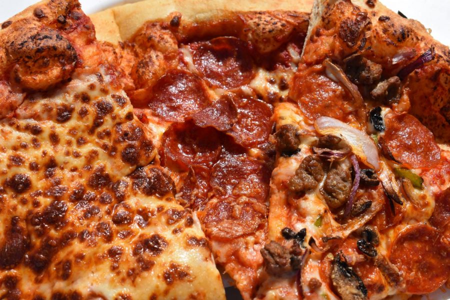 An extreme close up of the cult classic costco pizza.  Albeit a little greasy, the pizza is world renowned for its simple attitude and amazing flavor. 