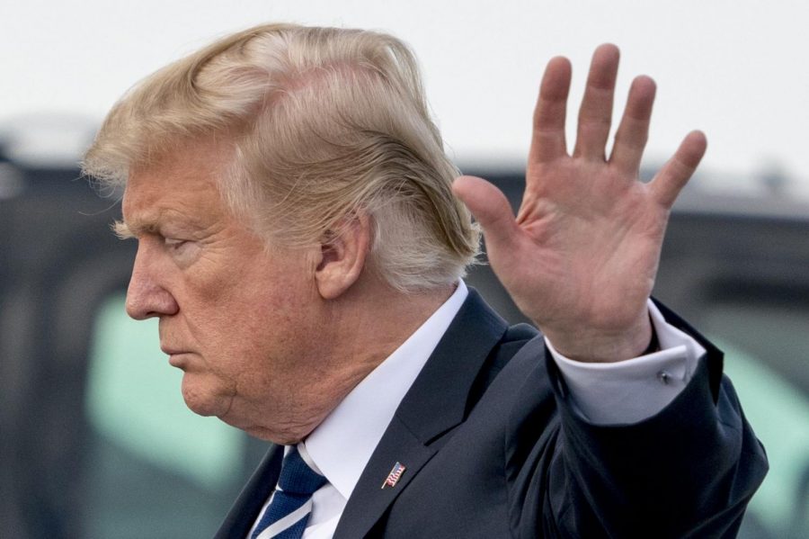 President Donald Trump turns away from the camera with an extended hand towards it. The commander in chief dismissed the idea that the U.S. is gearing up for a trade war over proposed aluminum and steel tariffs on Monday.