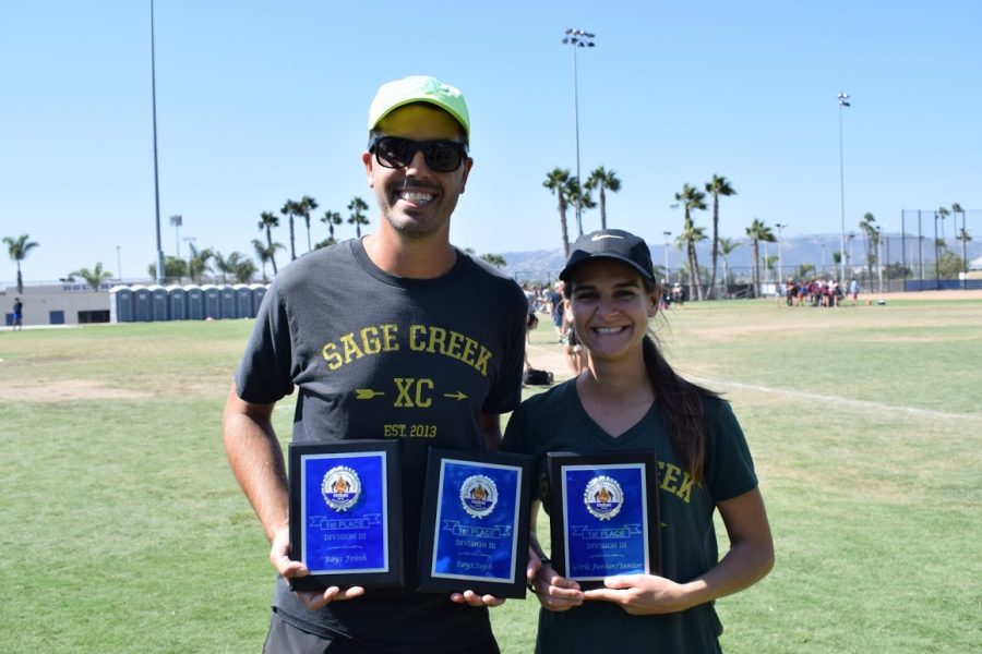 Cross country coaches, Jacob and Rachel Feiring hold three 1st place plauqes at the conclusion of this past Saturday’s Dana Hills Invitational. The Sage Creek cross country team took a large collective win this past Saturday, Sept. 22, with both the boys freshman, sophomore and girls junior/senior teams all placing 1st.
