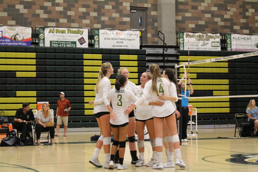 The varsity volleyball girls team gathers in the middle of the court for a brief hug to celebrate winning a point against the opposing team. Sage Creek took on San Dieguito Academy this past week, putting up a fierce fight winning 3-0.