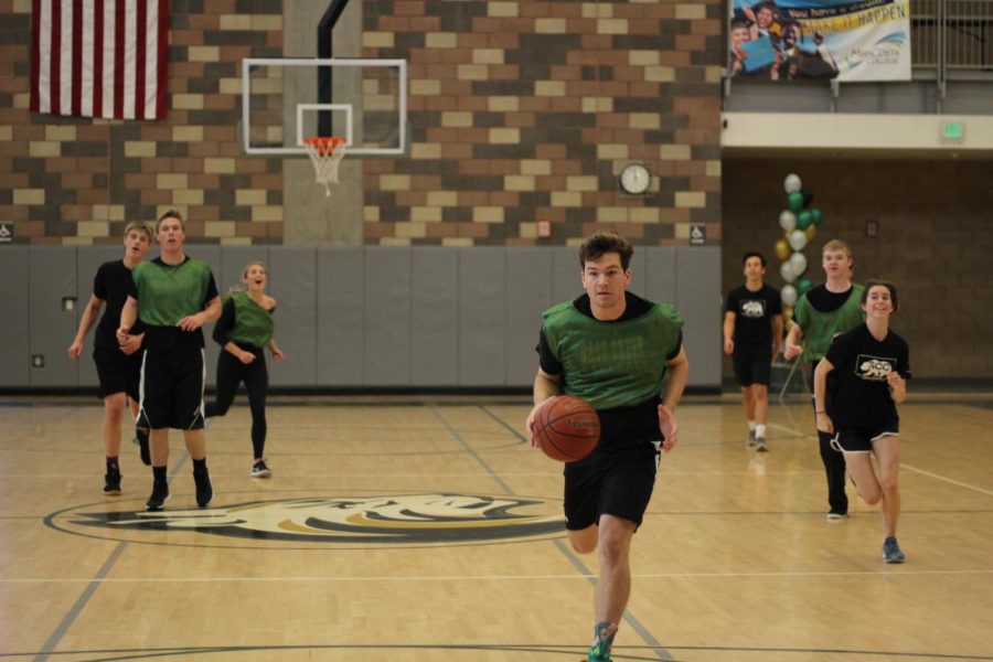 Senior Scott Anderson finds an open lane through the court to drive up for an easy layup. His team would win the game and advance to the championships against the teachers.