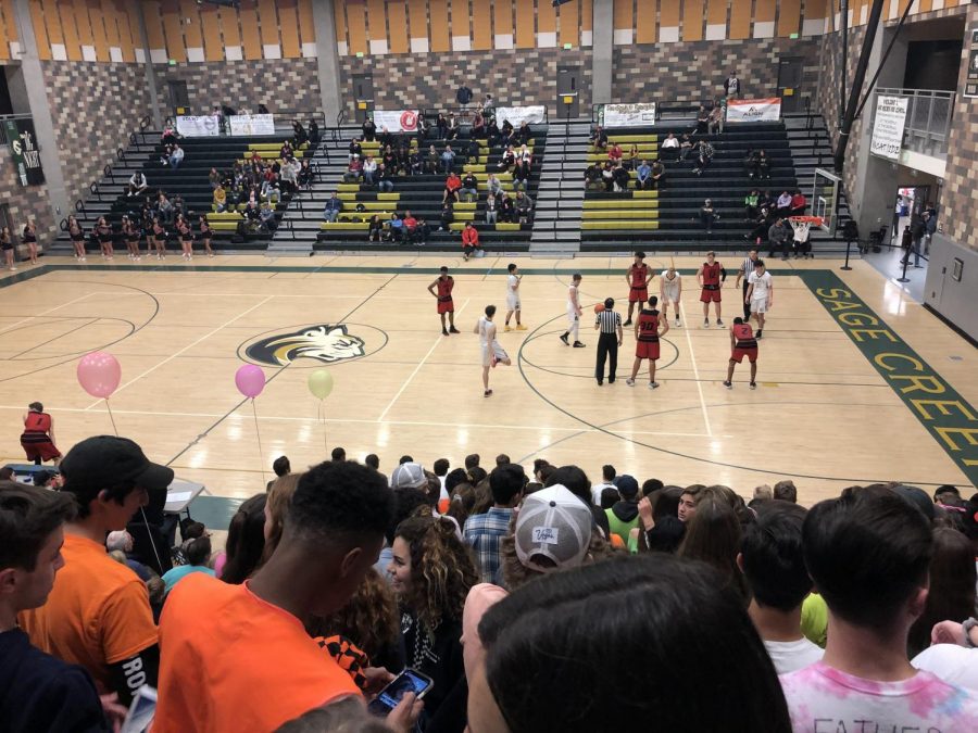 Students rally to support the boys varsity game sporting all different shades of neon on Jan. 11. This tough match combined with groovy music and bright colors made this game one to remember. 
