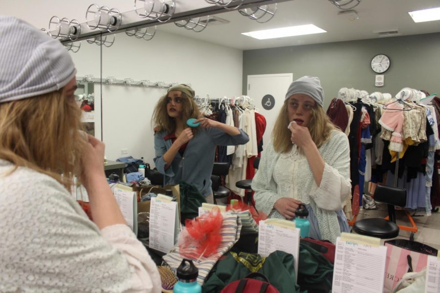 Hannah Katz and Emma Belnap do their hair and makeup before the show begins. Both Katz and Belnap are involved in advanced theater at Sage Creek regardless of the fact they are only sophomores. 