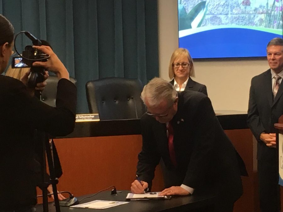 Mayor Matt Hall signs the contract after he is sworn in in City Hall on Dec. 11. This is the third time Hall has signed the mayoral contract.