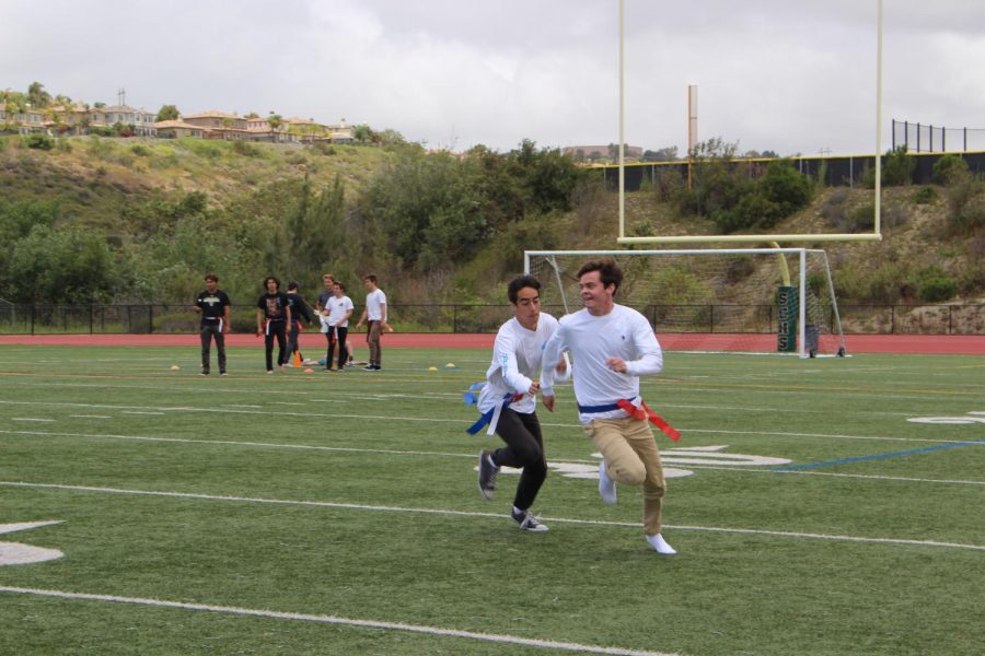 Two students chase each other in a flag football game. The flag football tournament was the first in Sage Creek history. 