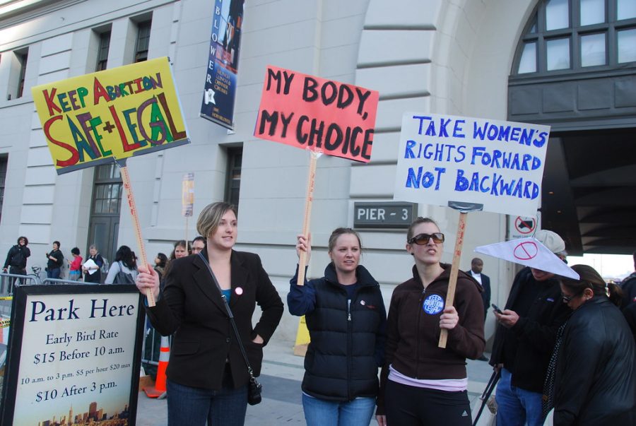 Three women demonstrate their first amendment rights by protesting for their reproductive rights. Throughout history, protesting has been a way to get the attention of politicians to pay attention to issues that the people care about.