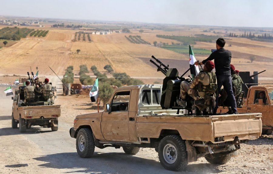 Syrian Rebels ride into the Syrian-Turkish border, backed by Turkey. On Oct. 9, Turkish Troops moved past the border into Syria.