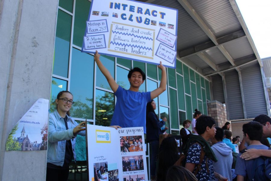 Interact Club holds up posters to promote their program and other activities they do. Club Rush took place on Wednesday, Oct. 2.