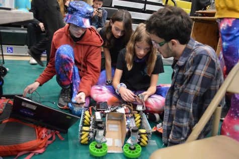 Team Level Up gathers around their robot to access hardware and software problems. Later on in the competition day, Level Up strived to semi-finals. 