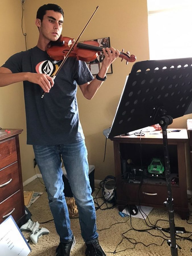 Orchestra student Josh White practices the Star Wars main theme on his violin in preparation for the Pops Concert. The Star Wars main theme is one of the pieces from a 6 movement Star Wars suite that will be performed on June 6. 