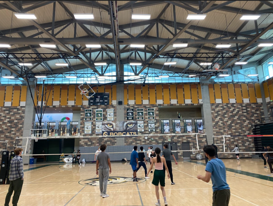 Students get ready for the volleyball to be served onto their side. Coach Savage plays music for a positive environment full of friendly competition.