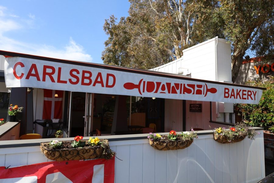 The Carlsbad Danish Bakery sign on a sunny sunday morning. The bakery offers an outdoor dining experience for those who would like to enjoy some coffee and baked goods. 
