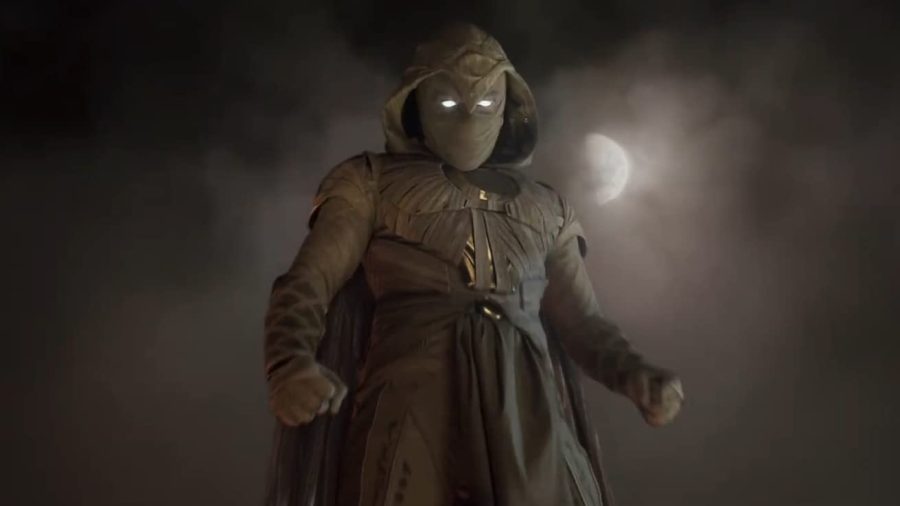 Moon Knight in full costume stands in front of the moon. Moon Knight’s two separate identities both have different costumes, Spector’s more ancient one and Grant’s more modern suit. 