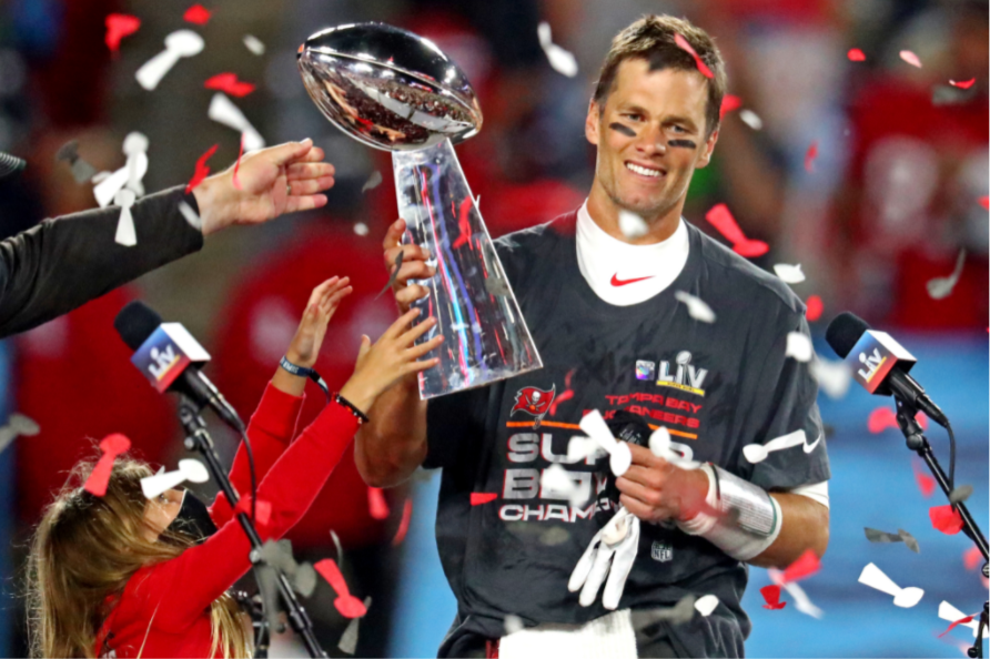 Tampa Bay Buccaneers quarterback Tom Brady smiles after winning his seventh Super Bowl. He holds the trophy as his team is announced the champions. 