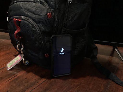 An iPhone opens up the TikTok app while laying on a school backpack. TikToK can be an outlet to socialization.