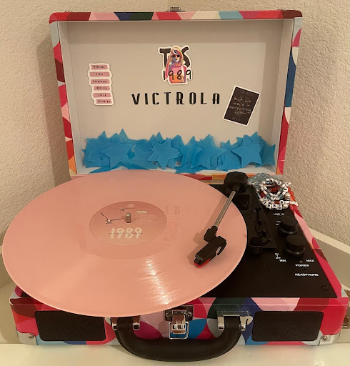 The Rose Garden “1989 (Taylor’s Version)” limited edition vinyl variation rests on a record player. The blue star confetti is sent out with any “1989 (Taylor’s Version)” order.