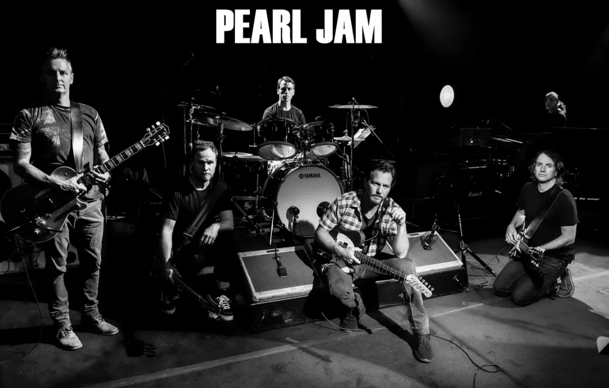 Pearl Jam formed in the year 1990. From left to right, Mike McCready (guitar), Jeff Ament (bass), Matt Cameron (drums), Eddie Vedder (vocals and guitar), and Stone Gossard (guitar) pose as a band on stage.