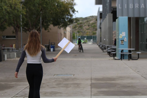 A female student protests by walking through the academic mall during class hours. She even proudly protested in front of Mr. Dan.