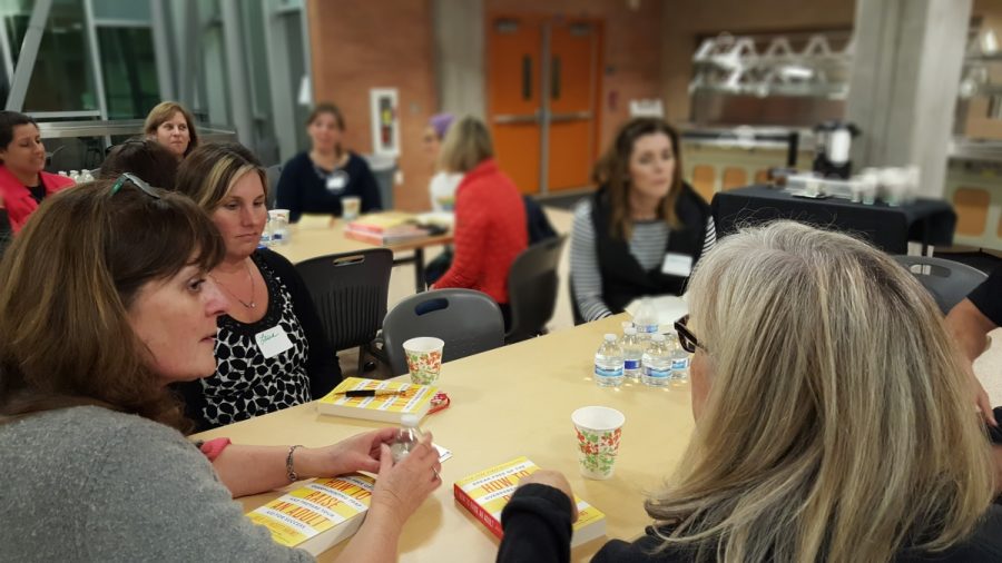 Teachers and guest parents sit and deliberate the novel, “How to Raise an Adult”
