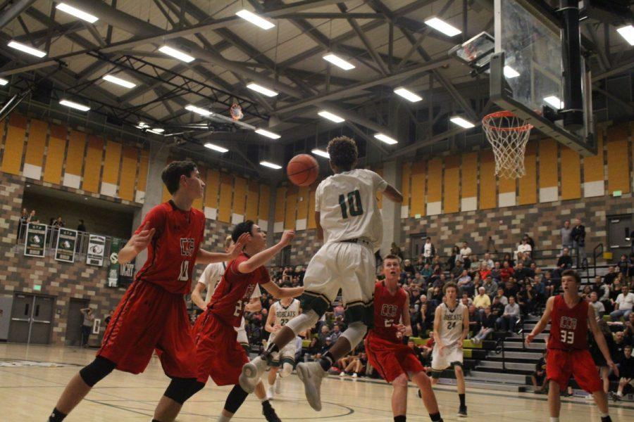 Freshman Jailen Nelson drives along baseline against the CCA Ravens