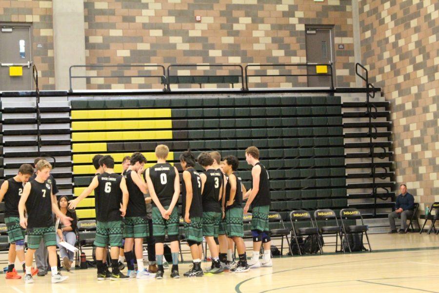 During a timeout, the varsity team huddles around to strategize for the rest of the fourth set.