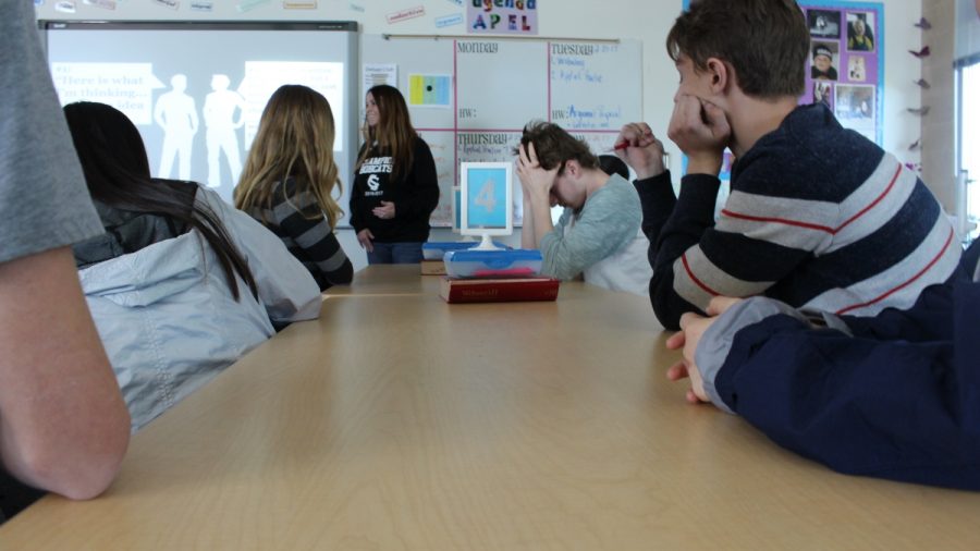 Students listen to a lecture from Mrs. Alberts in preparation for a Genius Project activity—some with eager interest, others not so much.
