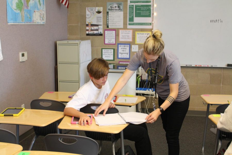 McLean aids student, Luke Beifus, in math class.