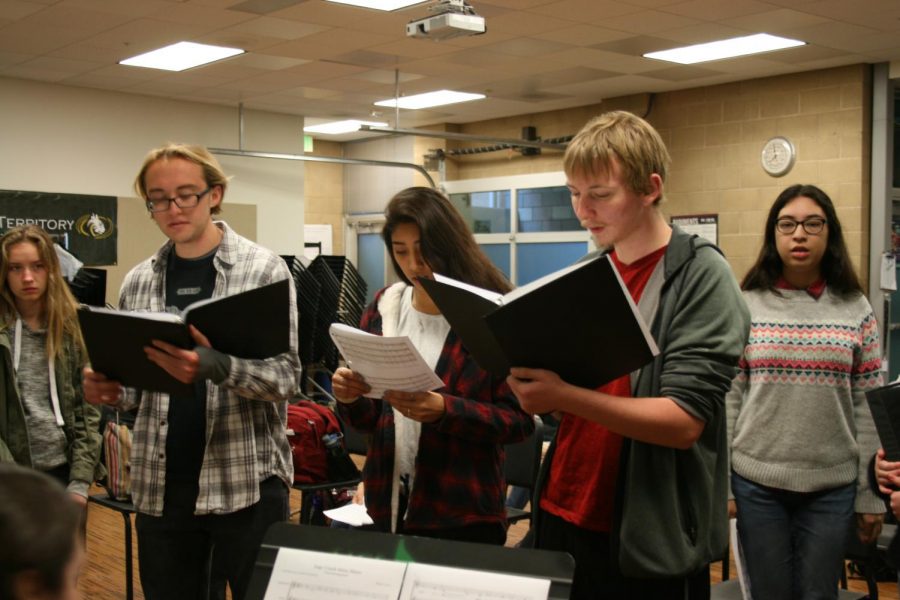 The choir stands while practicing the alma mater. The class is spending time
learning the song for the hoopcoming assembly.