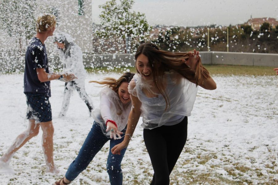 Seniors Paige Loeffler and Makenna Manti are seen running, as well as slipping, through Dr. Bronner's snow on the Wednesday of Hoopcoming week.