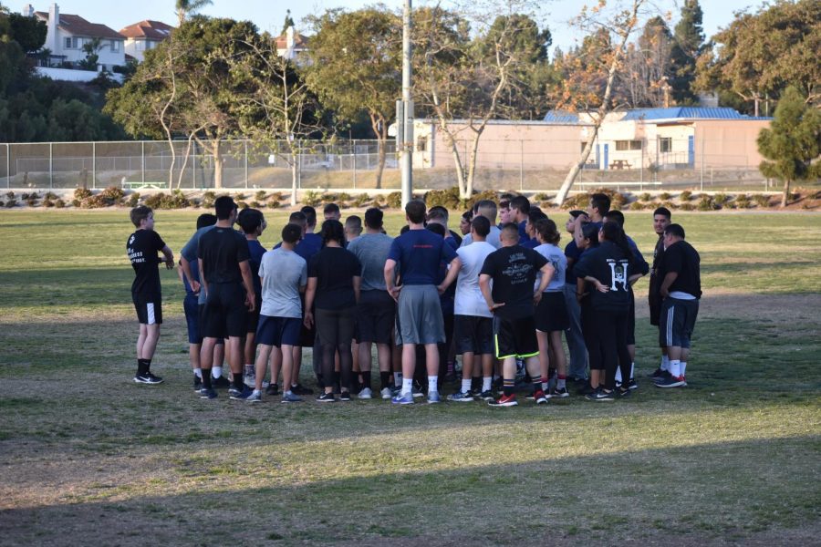 The marine recruits gather together around the sergeant after their workout is over.