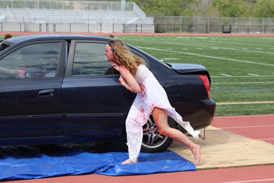 Senior Paige Loeffler rushes out of the vehicle to evaluate the extent of the injuries caused during the Every 15 Minutes simulation.