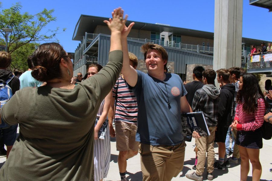 Senior Christian Davis high fives a faculty member while departing Sage Creek towards the conclusion of the senior walk-off ceremony.