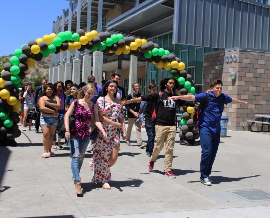 Erin Paulin and Mia Bodnar stand left of Jacob Nipper and Darius Rhamanian while beginning their departure from the Sage Creek campus at the senior walk off.