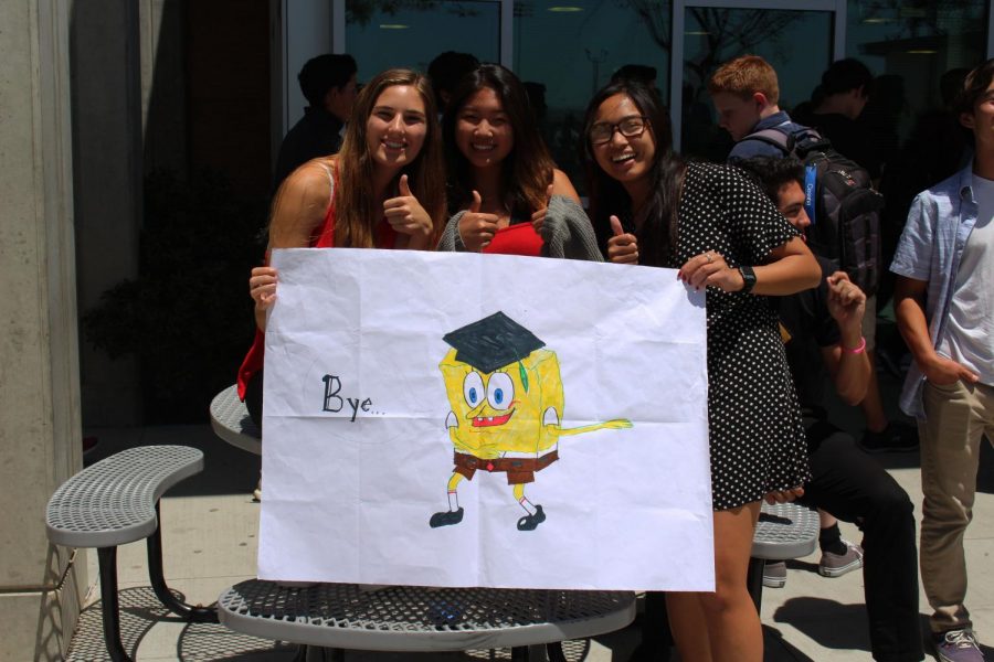 Juniors Summer Fitzgerald (left), Meghan Kim (center), and Kaelin Zablan (right) display a poster created by Zablan as a send off to the graduating class.