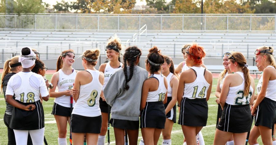 Members of Sage Creek’s girls field hockey team smile as their coach gives a motivational pep talk. During the first half of the game, the girls received fierce competition from Rancho Buena Vista High School.