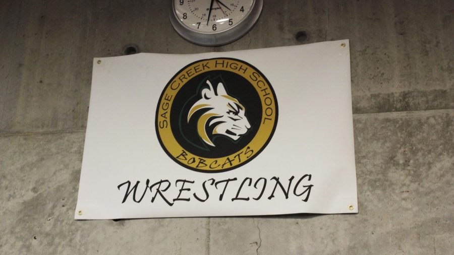 The wrestling sign hangs below the clock. This reminds wrestlers to not forget the team aspect of the program.