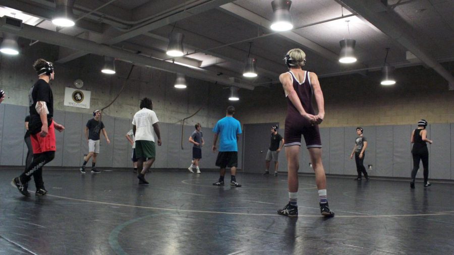 Freshman Peter Rubin stretches while waiting for coaches to give instruction. Muscle injuries are common in wrestling so the team makes it a necessity to be fully prepared for practices.