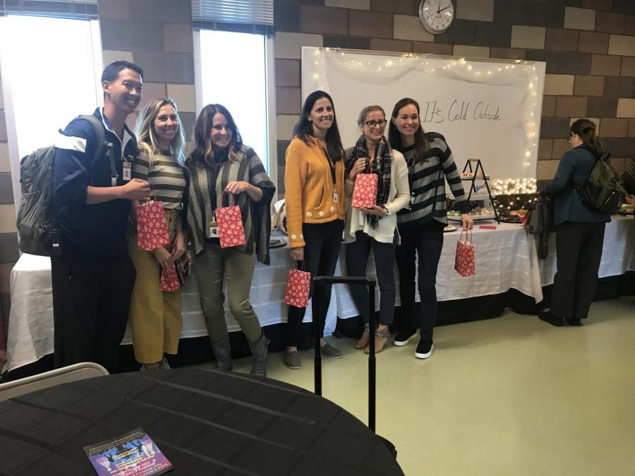 Some of Sage Creek’s teachers and staff pose on Wednesday, Dec. 12, with their treat-filled bags. PTSA collected various sweets through the week to show the teachers and staff how appreciated they are during the holiday season.