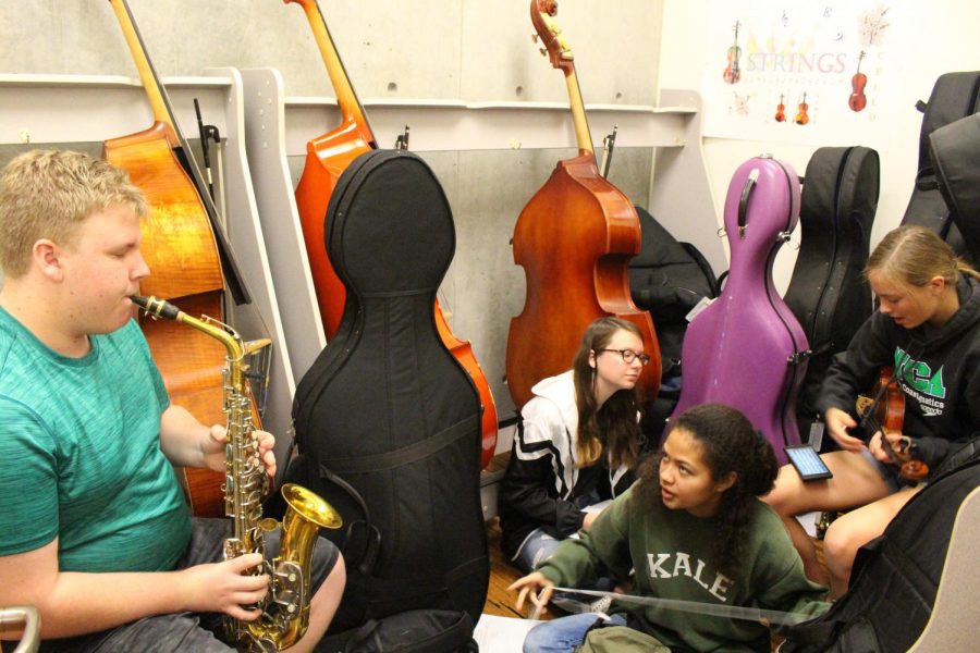 EJ Hardy practices a melody on his saxophone as his friends critique him. This is one of many instruments that Hardy is able to practice and play.