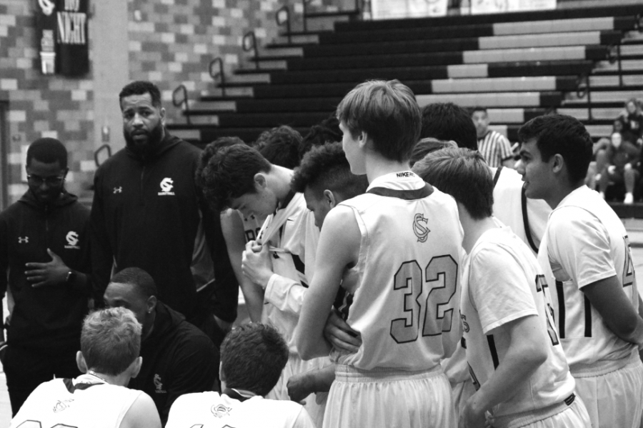 Varsity head coach Brandon Dowdy talks strategy as the Bobcats take a time out. During the team talk the players gather together to exclude the distractions and keep their head in the game. 