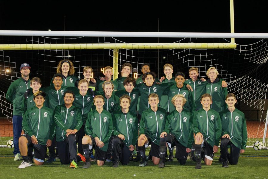 The team gathers for a photo under the field goal before their practice ends. The varsity team had 24 players in total; one freshman, four sophomores, four juniors and 15 seniors. 