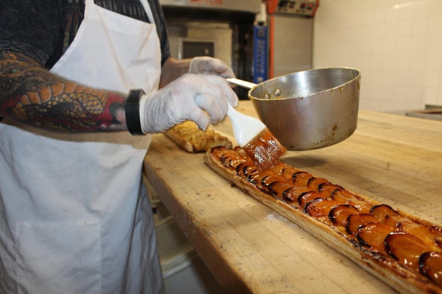 Olivier Baudier, father of Lysette Baudier and owner of the Carlsbad Village Pastry Cafe, meticulously spreads a layer of glaze over his famous apricot tart— the favorite of many. He— along with a few other friendly employees— have been working for hours already, but still, have smiles to share.