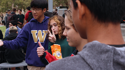 Sophomores Woojin Chung, Rhonan Fairbairn, Calvin Battaglia and David Aguilar (left to right) huddle together at lunch on Tuesday in 50-60°F weather. Anticipating warmer weather, ASB encouraged students to dress like it was summer in december. Many students showed up to school in hoodies instead.